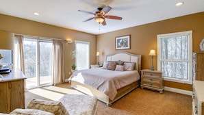 A bedroom with a bed, a desk, a dresser, a ceiling fan, and large windows. - Large Tazewell Home < 1 Mi to Norris Lake Access! (Tazewell)