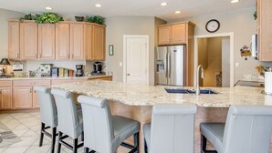 A modern kitchen with granite countertops, stainless steel appliances, and bar seating. - Large Tazewell Home < 1 Mi to Norris Lake Access! (Tazewell)