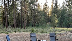 An outdoor patio with two lounge chairs and a fire pit.
