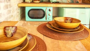 Une cuisine avec un mur en briques, un escalier en bois et un réfrigérateur turquoise d’époque.
