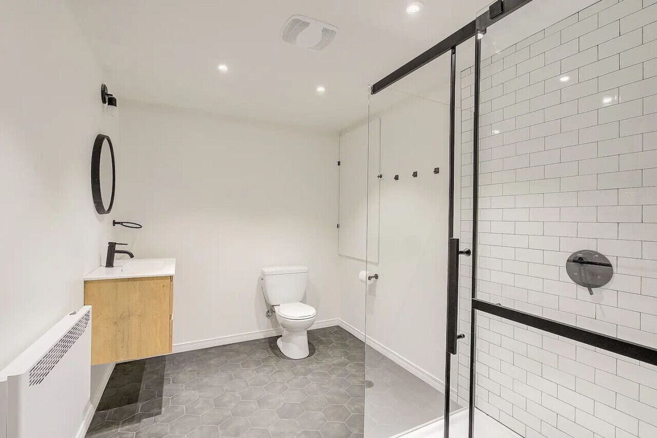 A modern bathroom with a toilet, a sink, and a shower area.