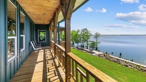 Une terrasse en bois offrant une vue sur un lac et des arbres.