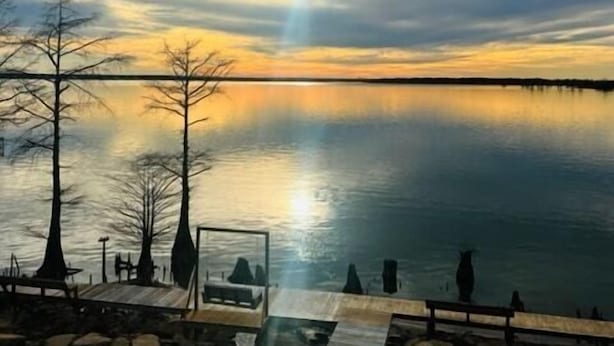 A lakeside view with a wooden dock, a bench, and a gazebo. - Eagle Lake RV Spot 50AMP, Private Boat Ramp (Vicksburg)