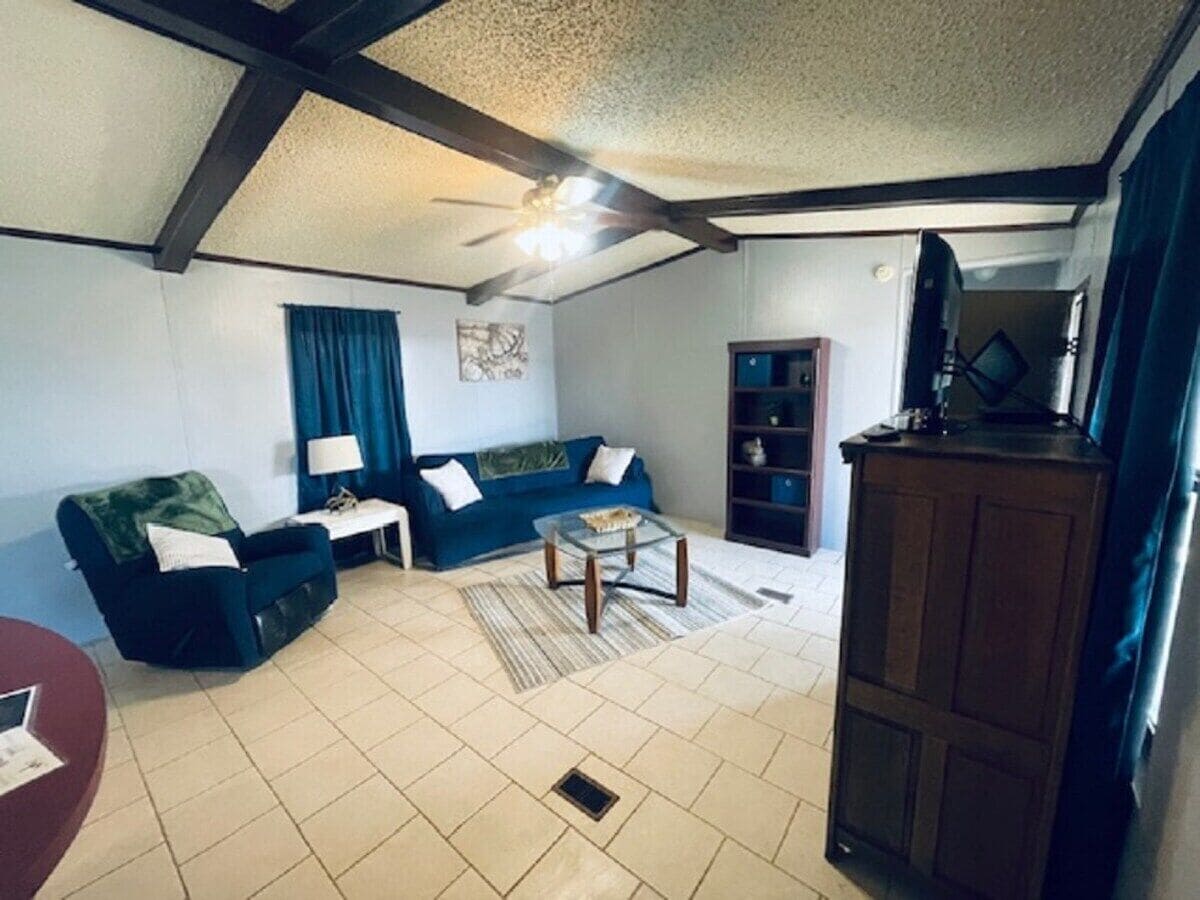 Una sala de estar con sofá, una mesa de centro y un aparador.