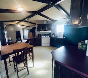A kitchen with a dining area, wooden furniture, and a white stove.