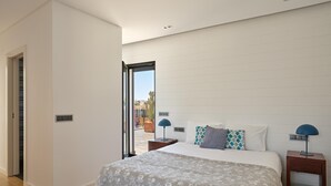 Ein Schlafzimmer mit einem Bett, zwei Nachttischen, einem Fenster und einer Tür.