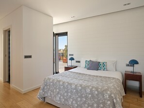 Een slaapkamer met een bed, twee nachtkastjes, een raam en een deur.