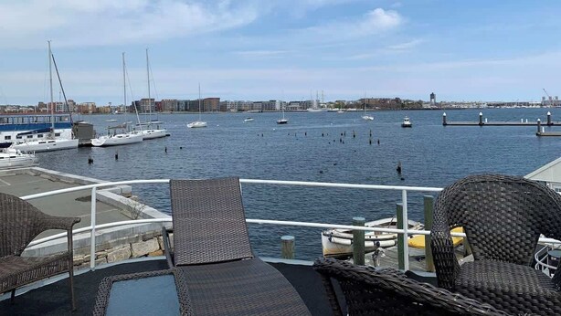 A marina with boats, a dock, and a view of the city skyline.