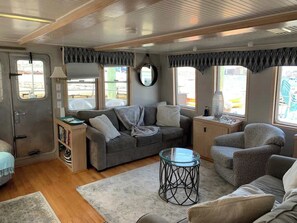 Un espacio habitable compacto con sofá, sillón y una pequeña mesa redonda.