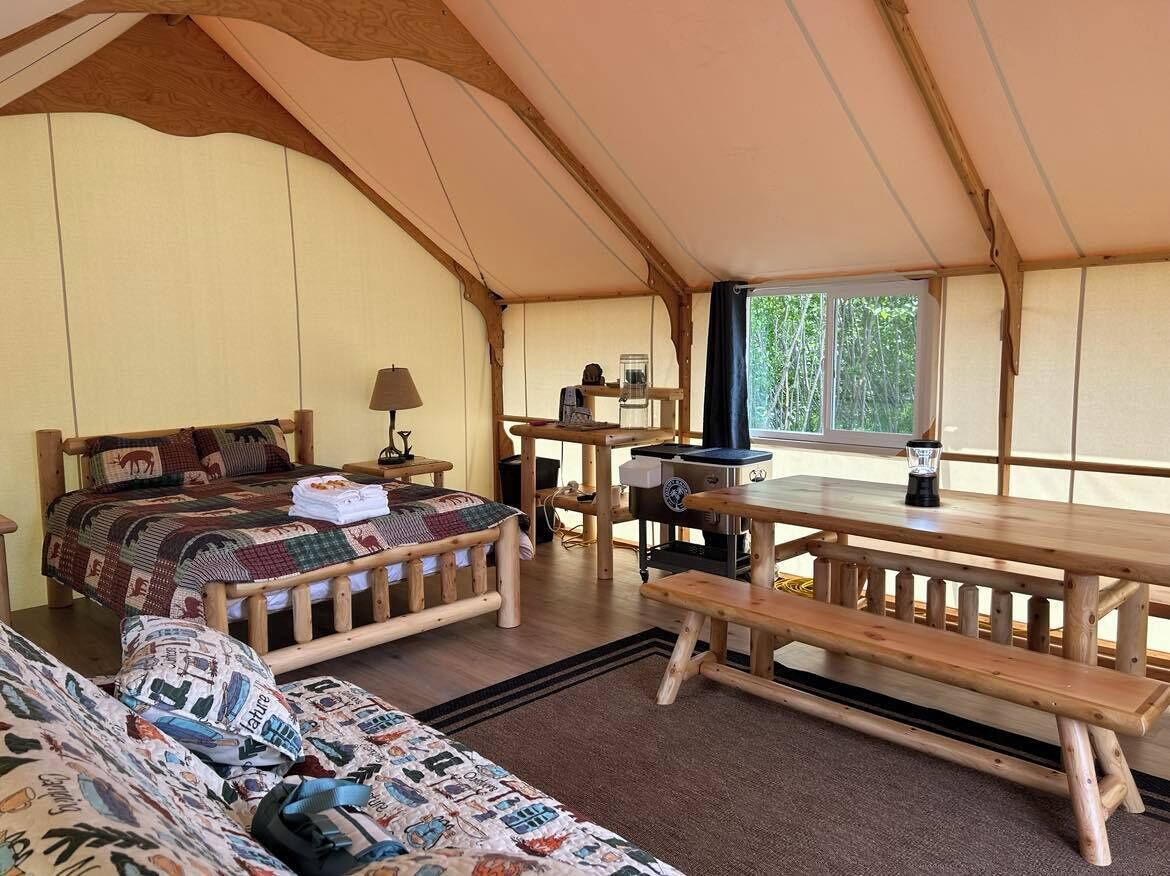 Une pièce confortable avec un lit, une table et un banc.