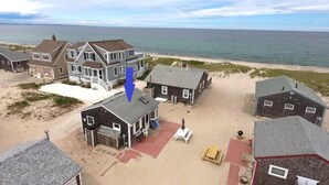 A beachfront property with multiple houses, a sandy beach, and the ocean in the background.