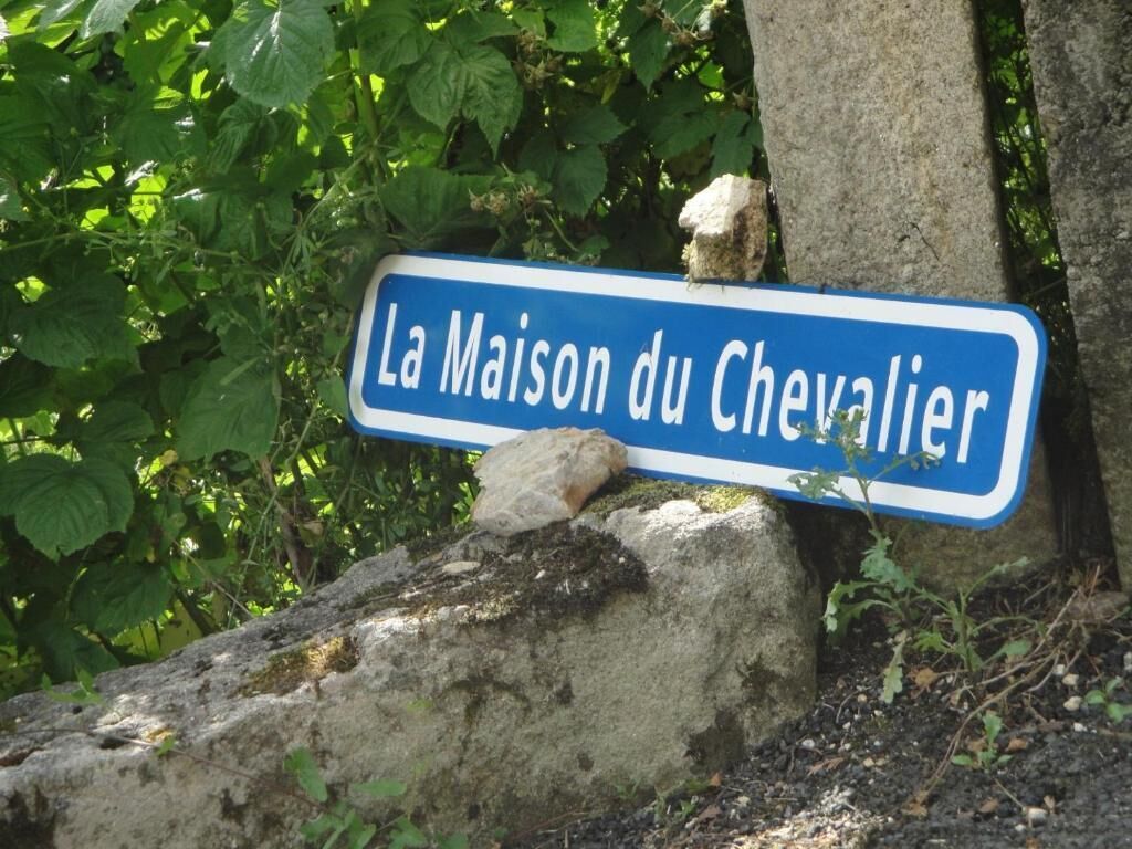 En skylt med texten ”La Maison du Chevalier” på en blå bakgrund med vita bokstäver.