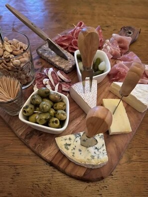 A wooden board with various cheeses, olives, and meats. - La Maison du Chevalier - Chambres et tables d'hôtes - adults only (Marat)