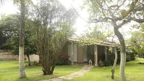 A house with a covered porch, a lawn, and a pathway leading to the entrance.