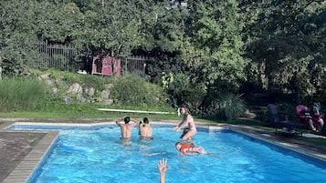 Una piscina al aire libre de temporada, sombrillas