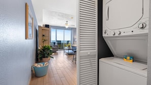 A modern apartment with a laundry room, a dining area, and a view of the city. - Glorious Oceanfront Escape: 1BR Condo with Private Balcony @ Ocean Walk Resort (Daytona Beach)