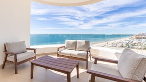 A balcony with a view of the beach and ocean.