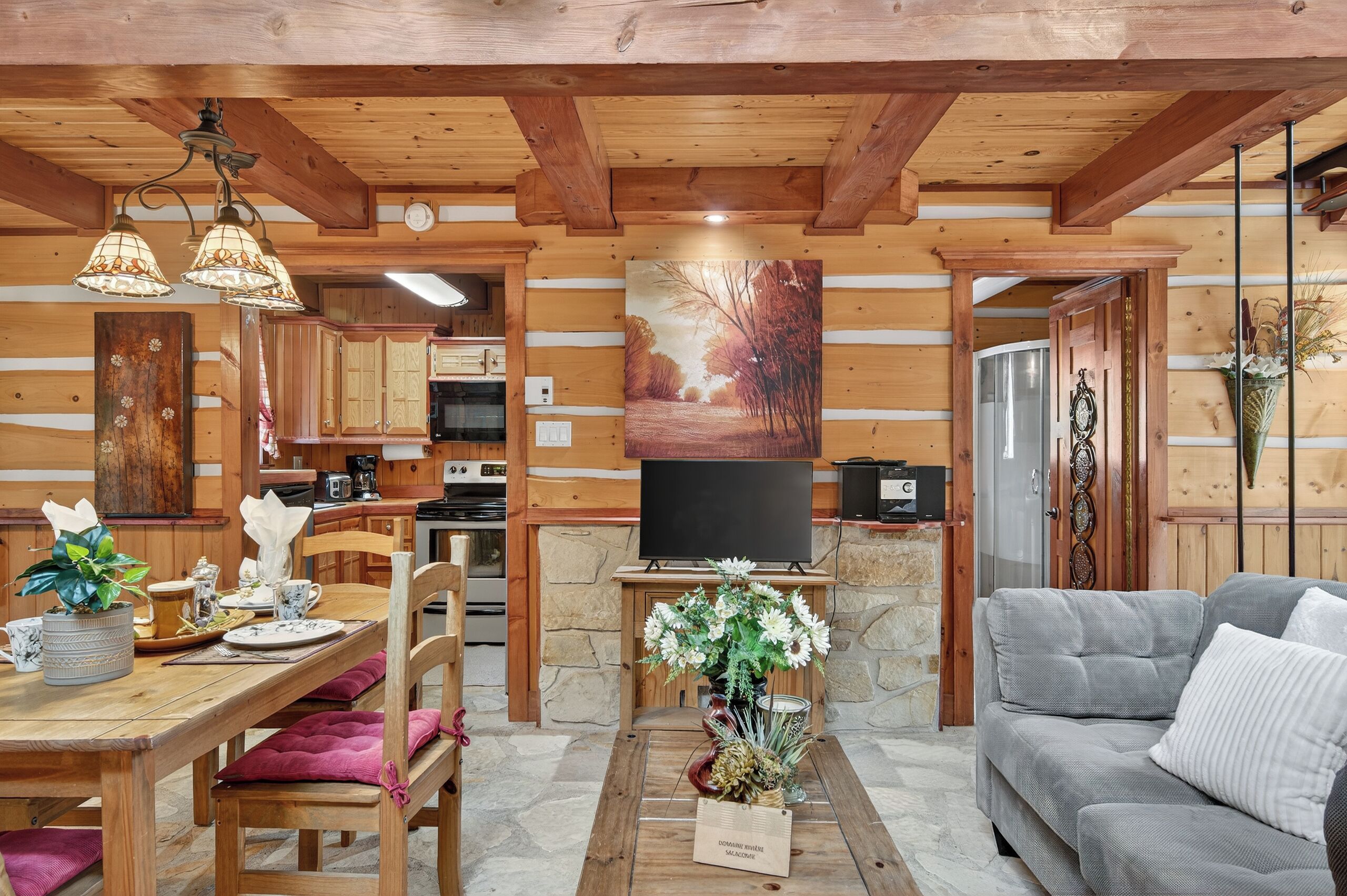 Un interior de cabaña acogedor con comedor, sala de estar y cocina.