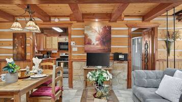Un interior de cabaña acogedor con comedor, sala de estar y cocina.