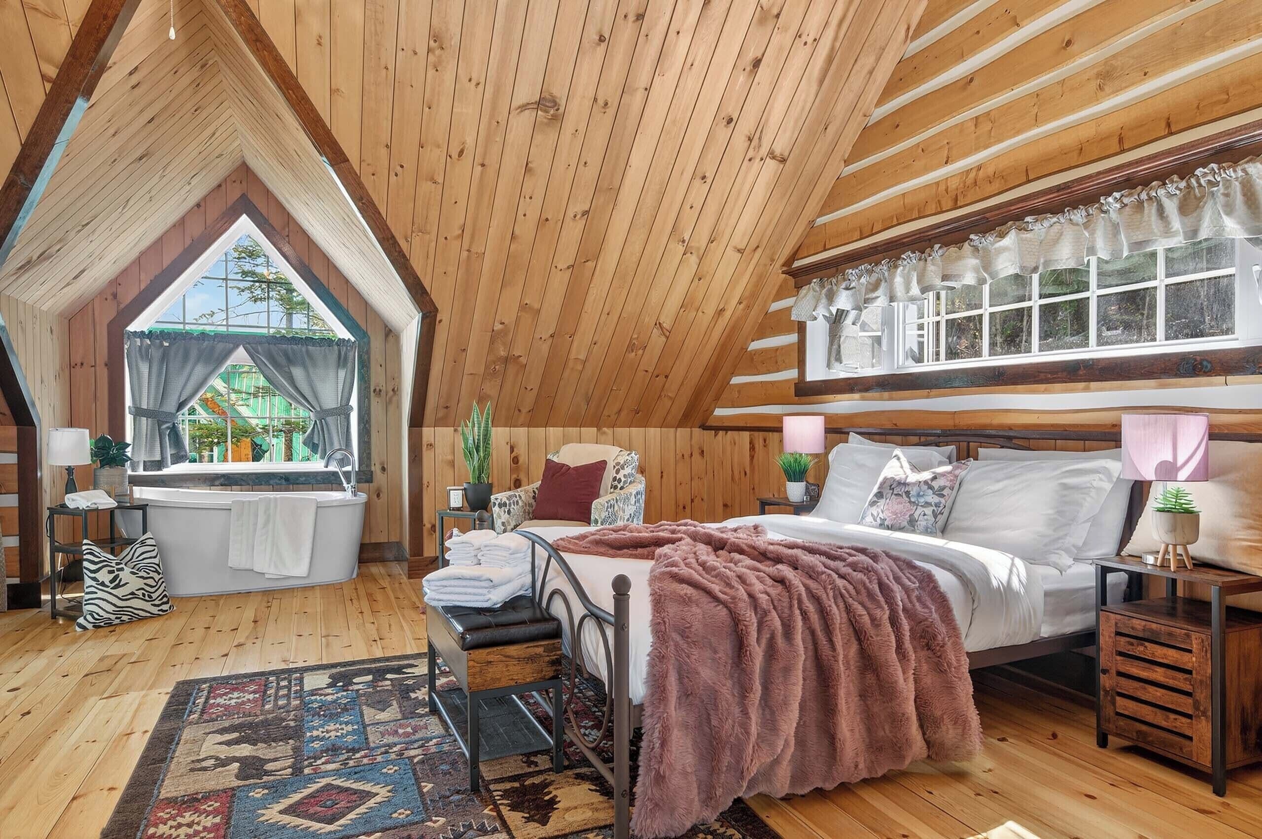 Un dormitorio acogedor con una cama grande, una ventana con cortinas, una mesita y una mesita de noche.