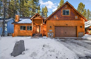 A wooden cabin with a front porch, a garage, and a snow-covered driveway. - Charming Summit Cabin-Hot Tub-5 Min Walk To Slopes (Big Bear Lake)