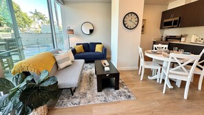 Ein modernes Wohnzimmer mit Sofa, Couchtisch und Essbereich.