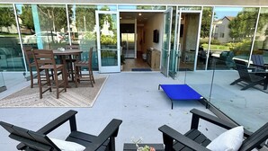 Eine Außenpatio mit Lounge-Möbeln, einem Tisch und einem Tischtennisschläger.