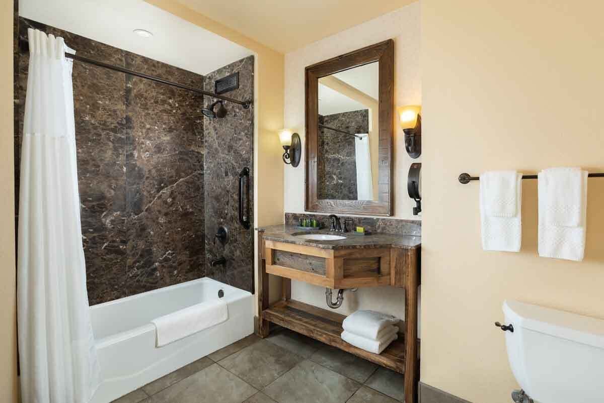 Un baño con bañera, ducha, tocador e inodoro.