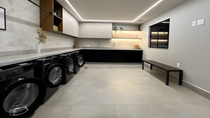 A modern kitchen with built-in appliances, a bench, and a window. - Noroeste - moderno e central (Brasília)