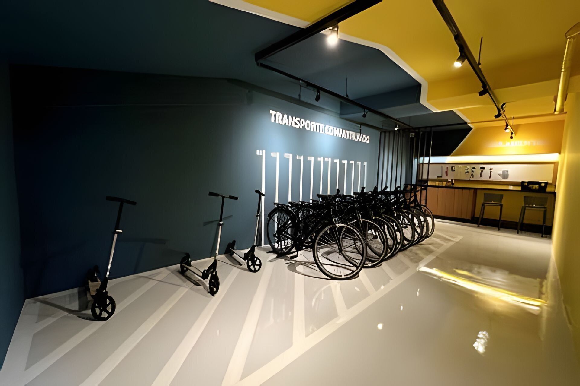 Un espace intérieur moderne, avec un mur sur lequel est inscrit le mot « TRANSPORT » et une rangée de vélos.