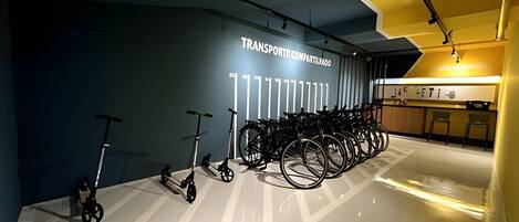 Un espace intérieur moderne, avec un mur sur lequel est inscrit le mot « TRANSPORT » et une rangée de vélos.