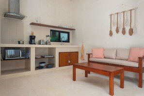 A compact living space with a kitchenette, a sofa, and a coffee table.