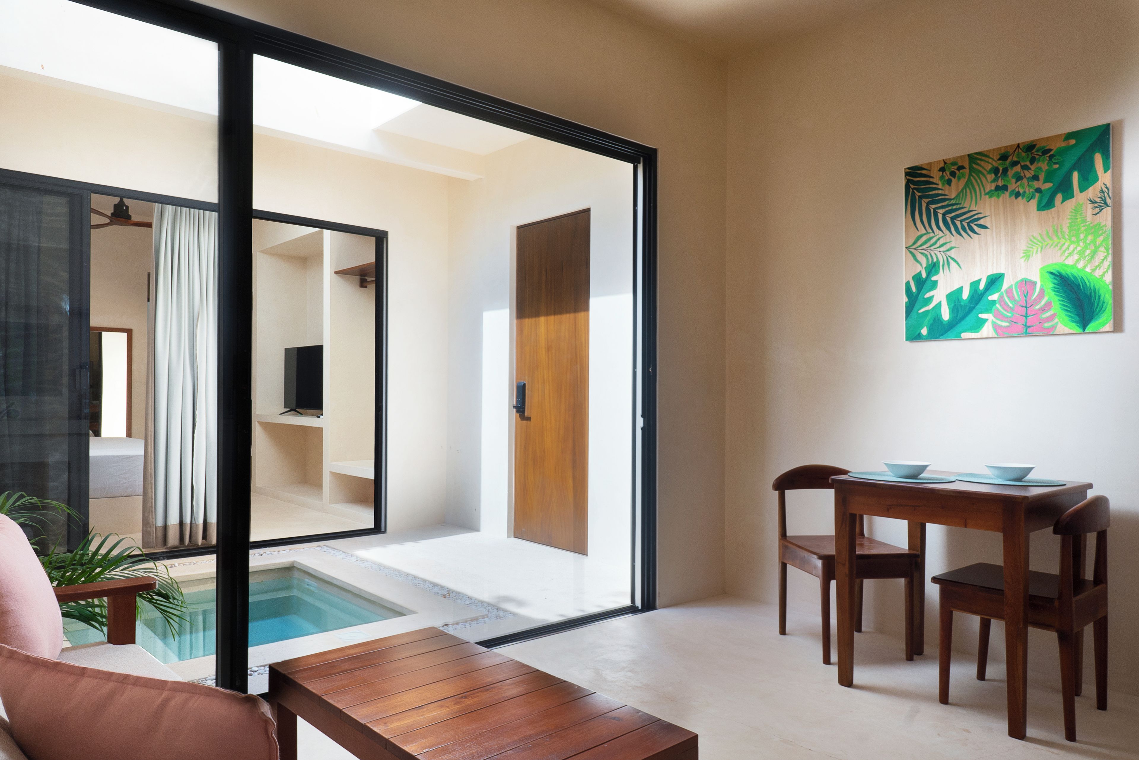 A modern interior with a pool, a dining area, and a living space with a sliding glass door.