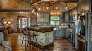 A spacious kitchen with a large island, modern appliances, and a rustic wooden interior.
