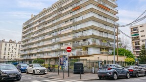 A multi-story residential building with balconies, a no-entry sign, and parked cars. - Appartement Leroy, balcon - Welkeys (Clichy)