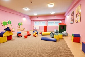 A playroom with pink walls, a window, and various toys on the floor. - Geovita Dzwirzyno (Kołobrzeg)