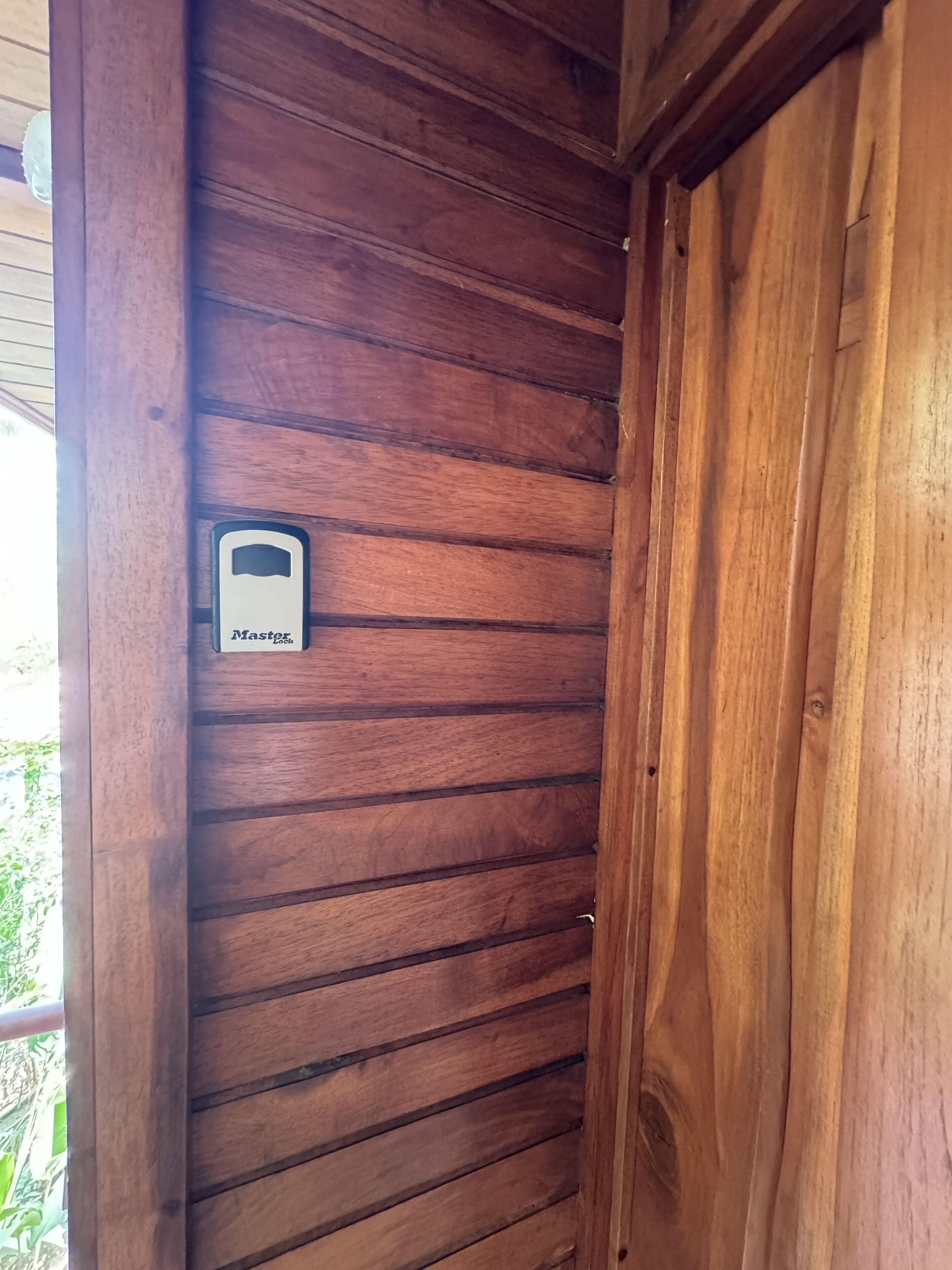 Une porte en bois dotée d’une serrure numérique et d’une petite plaque.
