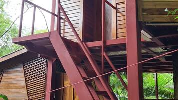 Eine Holzhütte mit einer roten Außentreppe, die zu einem Balkon führt.