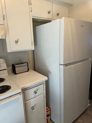A kitchen with a white refrigerator, a toaster, and a stove. - Affordable Townhome in Gulf Breeze Florida is ready for guest. (Gulf Breeze)