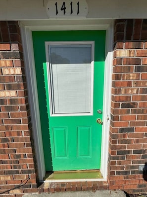 A green door with a white window and a number '1411' above it.