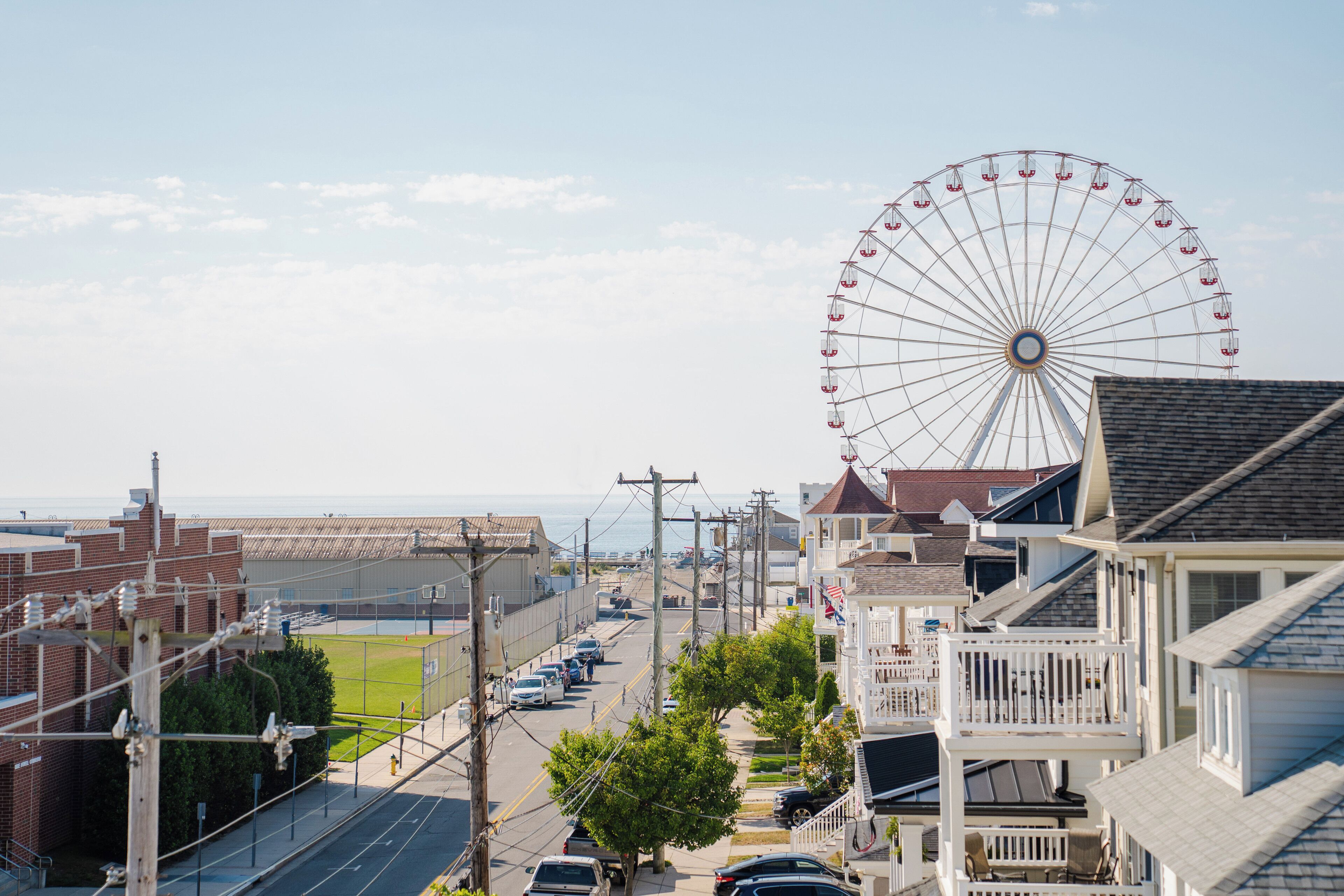 A coastal town with a prominent Ferris wheel, residential buildings, and a sports field.