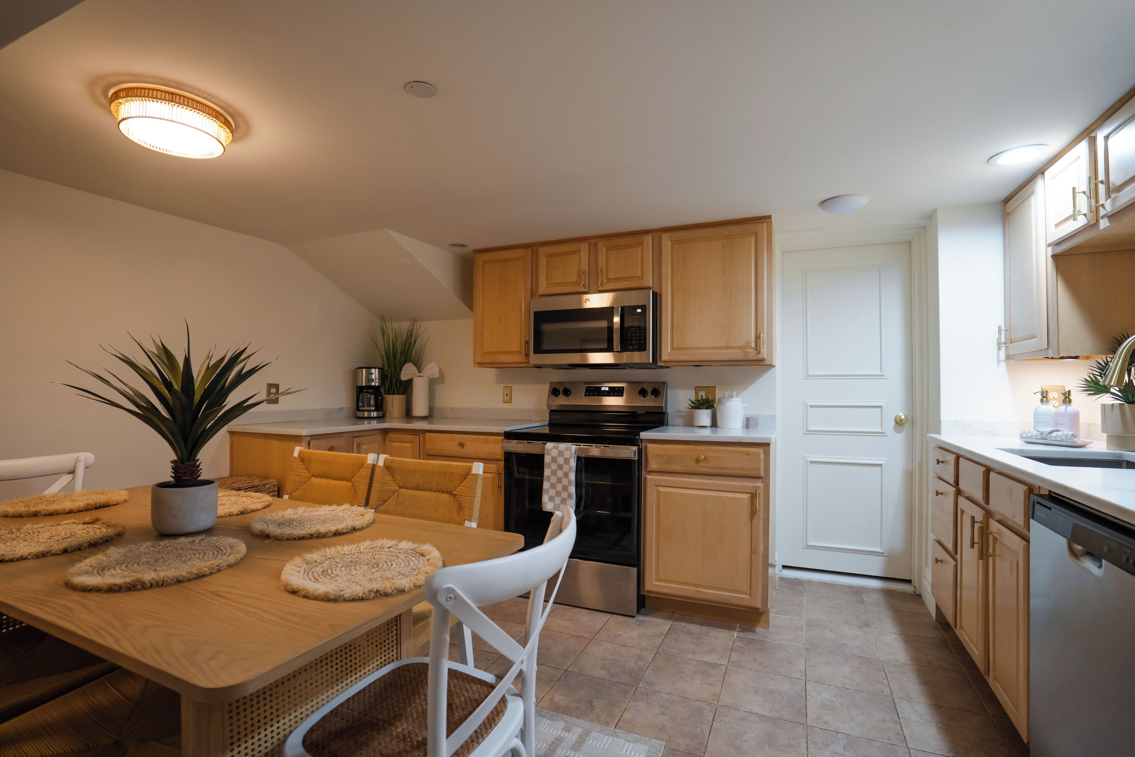 A modern kitchen with wooden cabinets, a stainless steel microwave, and a built-in oven.