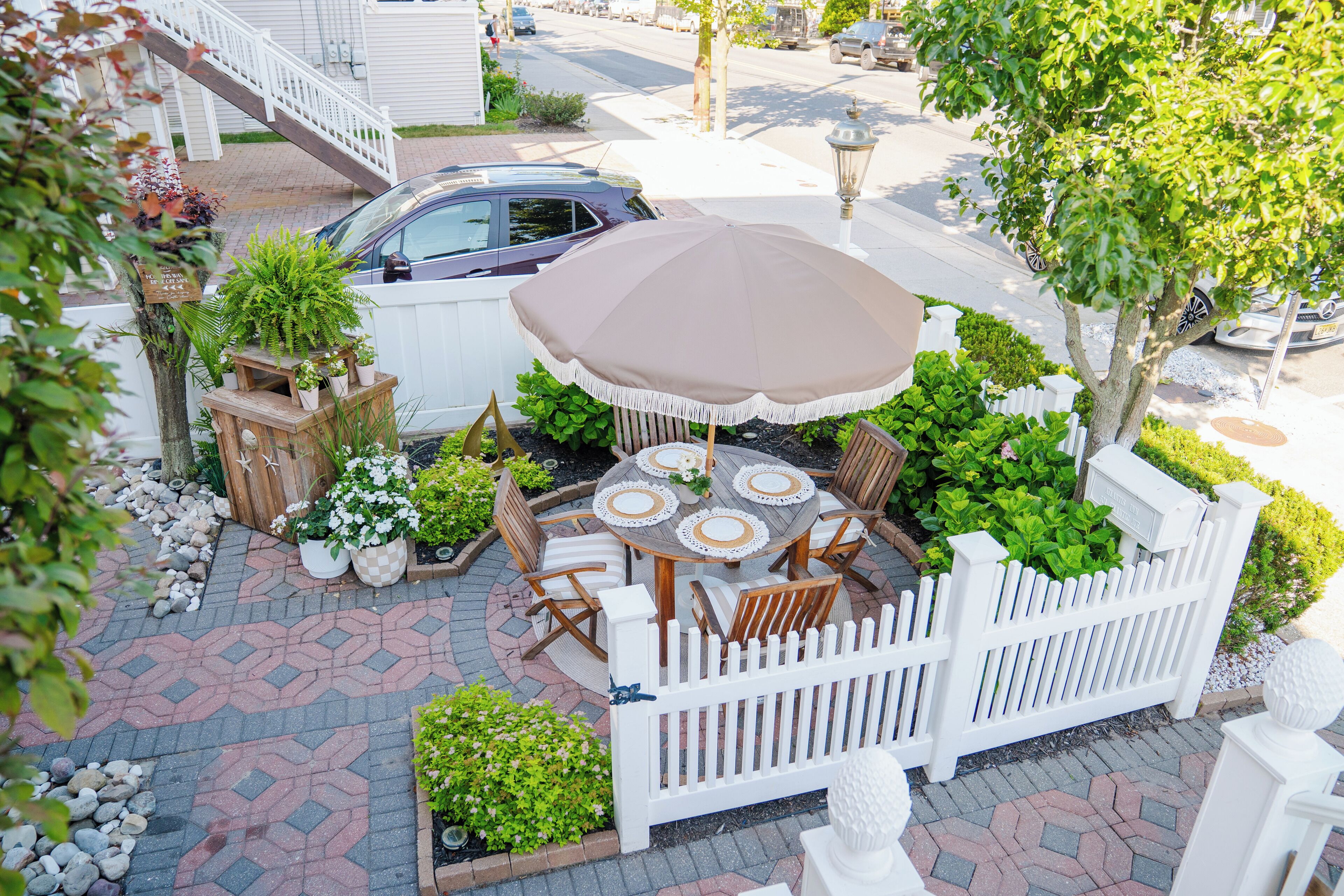 A patio area with a round table, chairs, and a large umbrella.