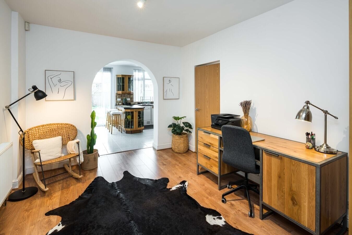 Ein modernes Wohnzimmer mit einem Holztisch, einem schwarzen Lederteppich und einem Essbereich im Hintergrund.