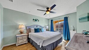 A bedroom with a bed, nightstands, a ceiling fan, and a view of the outside. - Private Beach Access! Free Activities Fun Pass! Ciboney 4013! (Miramar Beach)
