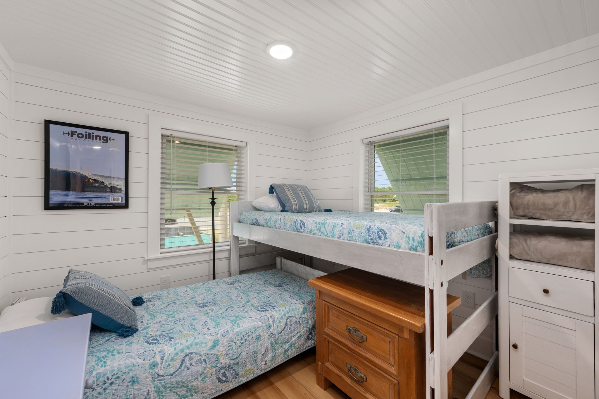 A room with bunk beds, a desk, and a lamp.