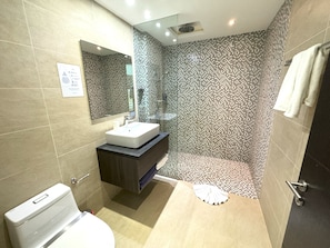 A modern bathroom with a toilet, sink, and shower area. - Private studio at Twin Sands Resort (Patong)