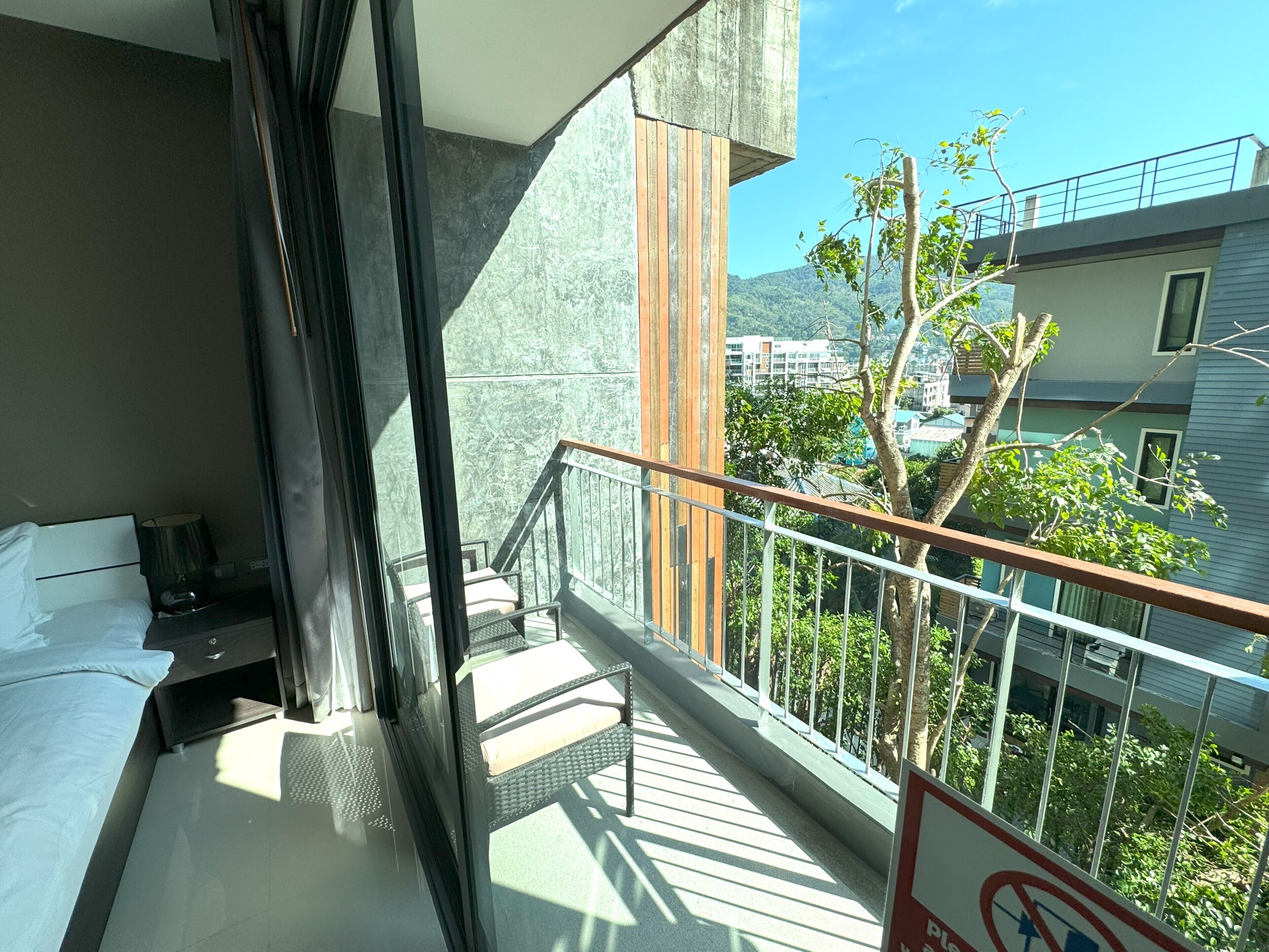 A balcony with a view of buildings and trees.