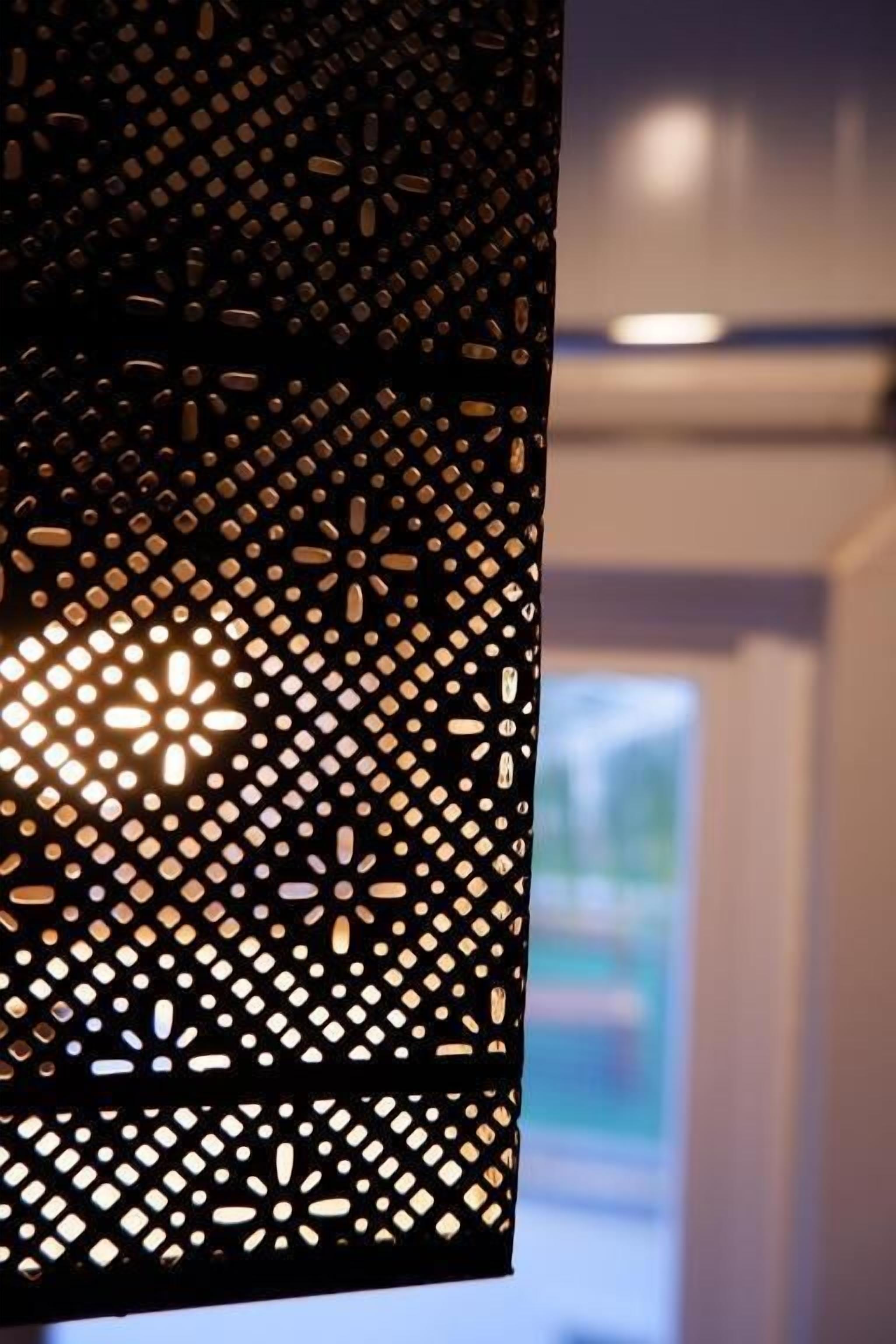 A hanging light fixture with a geometric pattern.