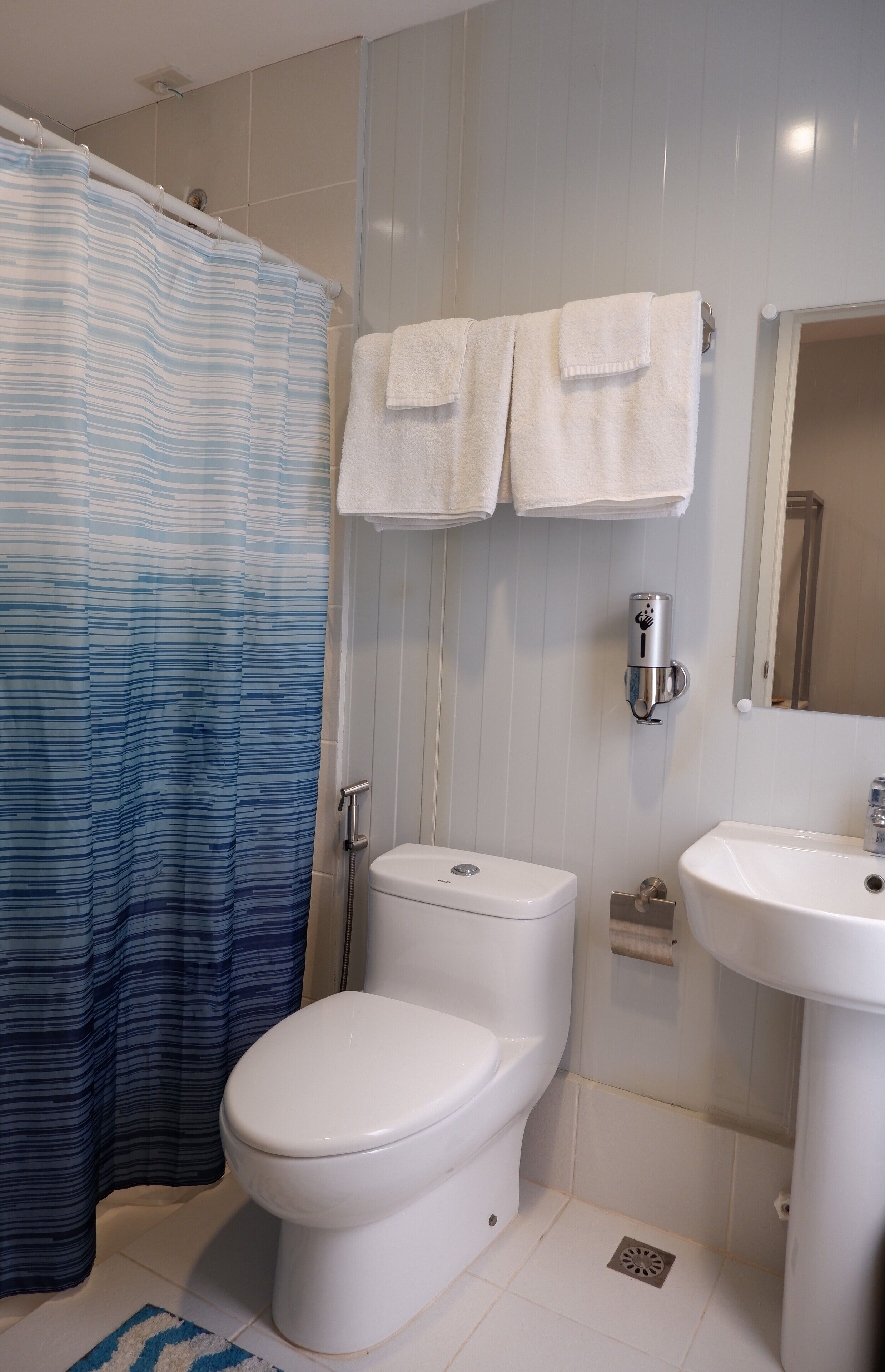 Een douche, een regendouche, een bidet, handdoeken